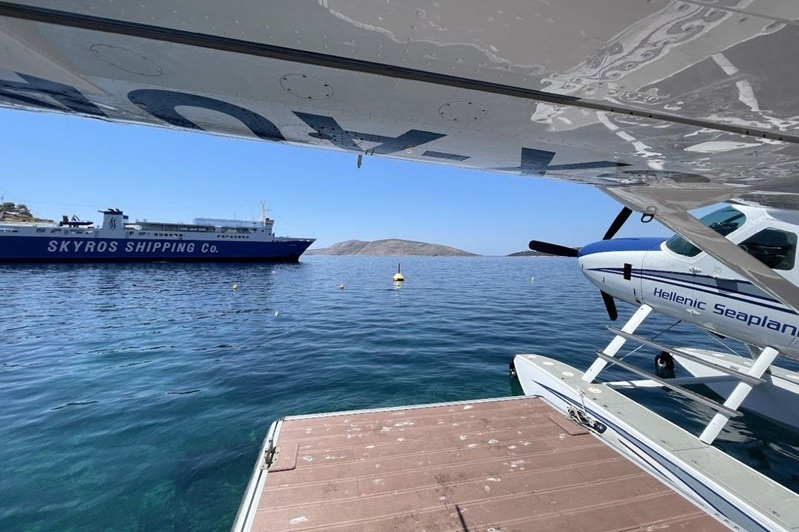 Ein Wasserflugzeug im Hafen von Skyros neben einer herkömmlichen Fähre, was die Forderung nach einer verbesserten regionalen Anbindung unterstreicht.