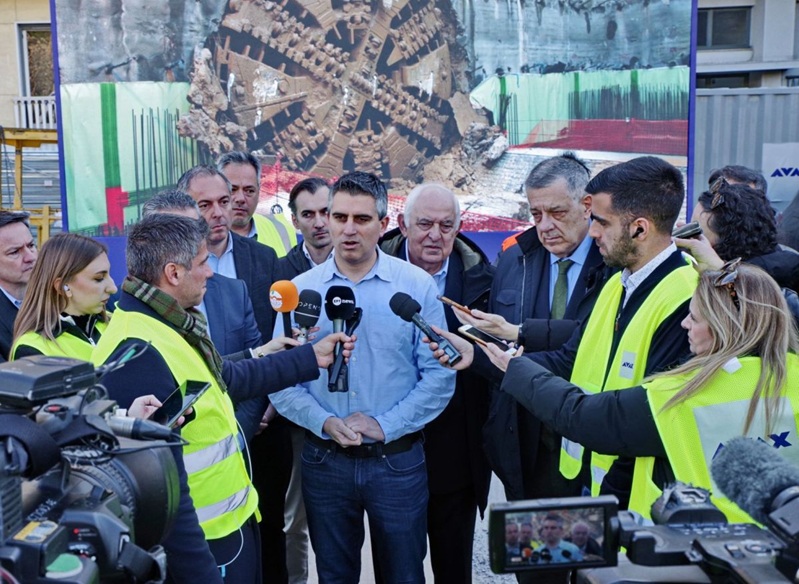 Der griechische Infrastruktur- und Verkehrsminister Christos Dimas spricht nach dem Durchbruch des 5,1 Kilometer langen Tunnelabschnitts der Athener U-Bahn-Linie 4 vor der Presse, im Hintergrund ist die neu fertiggestellte Tunnelbrust zu sehen.